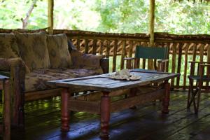 a couch and a coffee table on a porch at Baker & Sons Safari Company in Kwangwazi