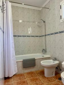 a bathroom with a tub and a toilet and a sink at Casa Marina by Vulcano Homes in Arrieta +28 photos