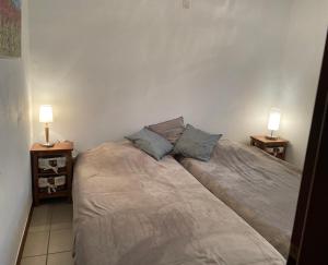 a bed in a bedroom with two lamps on tables at Le Hérou in Houffalize