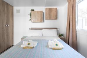 A bed or beds in a room at Club del Sole Marina Romea Easy Camping Village Még 37 kép