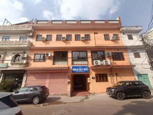 a building with two cars parked in front of it at Bhiwani Guest House in Jaipur