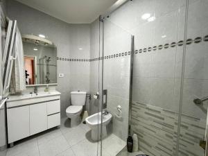 a bathroom with a toilet and a glass shower at Apartamento 3 habitaciones en Plaza de España 6PAX in Vigo