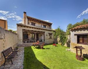 a backyard of a house with a grass yard at Villa De Urueña Casa de Ilustres in Urueña