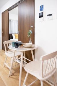 a white table and chairs in a room at The Peak Tengachaya in Osaka