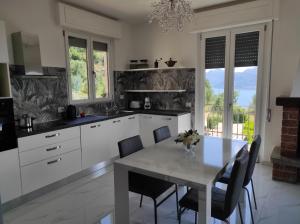 biała kuchnia ze stołem i krzesłami w obiekcie House Paradise w mieście Perledo