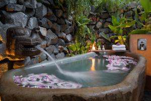 a bath tub with a fountain in a garden at Lynnaya Urban River Resort in Siem Reap