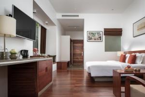 a bedroom with a bed and a kitchen with a table at Lynnaya Urban River Resort in Siem Reap
