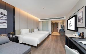 a hotel room with a large white bed and a desk at Atour Hotel Kunming Tongde Plaza Beijing Road in Kunming