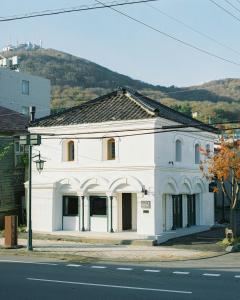 a white building on the side of a street at Portside Inn Hakodate in Hakodate +17 photos