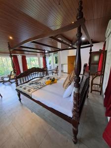 a bedroom with a large wooden bed in a room at Dambullawatha Bungalow Garden Villa in Hikkaduwa