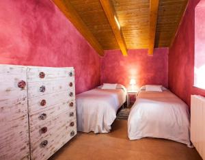 two beds in a room with pink walls at La Xiquella, formatges artesans i masoveria in Bas