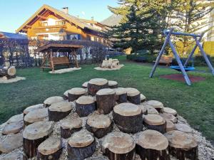 Una pila de troncos en un parque con un área de juegos infantiles en Bergsonne B15 Montana Haus, en Oberstdorf