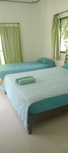 クッド島にあるChom Suan Farmstayのベッドルーム1室(青いシーツと窓付きのベッド2台付)