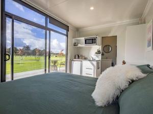 a bedroom with a bed and a large window at Rural retreat - Rua cabin in Ohakune