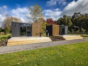 a modern house with two modular buildings in a field at Rural retreat - Rua cabin in Ohakune