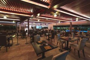 ein Restaurant mit Tischen und Stühlen in einem Raum in der Unterkunft Nicolaus Prime Villas Resort in Costa Rei