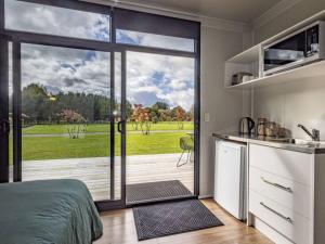 a kitchen with a large sliding glass door with a patio at Rural retreat - Rua cabin in Ohakune +9 photos