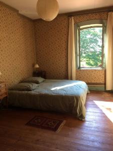 a bedroom with a bed and a window at Grande Gte Du Chteau Des Moriers Fleurie in Fleurie