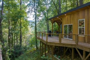 a house in the woods with a wrap around deck at Artist’s Palette by AvantStay Colorful Retreat in Fairview