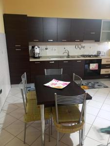a kitchen with a black table with chairs and a kitchen counter at La Corte dei Morra in Venafro +40 photos