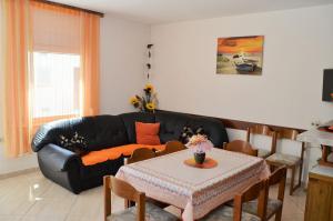 a living room with a black couch and a table at Apartments Ruza in Supetarska Draga