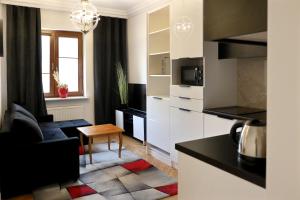 a kitchen and living room with a couch and a table at Apartamenty Długa 27 Glamour in Łomża