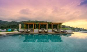 - une piscine dans un complexe avec des chaises et un kiosque dans l'établissement Panora sea view -modern facilities walk to beach, à Surin Beach