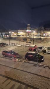 two cars parked in a parking lot at night at Apartamenty Długa 27 Glamour in Łomża