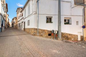 a cobblestone street in a city with white buildings at Casa Rural San Antón in Quesa