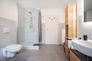 a bathroom with a shower and a toilet and a sink at Stylische große 5-Zimmerwohnung-WLAN-Free Parking- in Beckum +49 photos