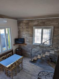 a living room with a table and a staircase at Petit LOFT Jardin Terrasse Climatisation WI FI Parking public gratuit in Elne