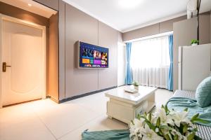 a living room with a couch and a tv on a wall at Xi'an Yongning Apartment Hotel in Xi'an +22 photos
