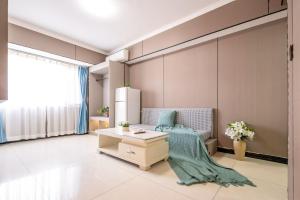 a living room with a refrigerator and a table at Xi'an Yongning Apartment Hotel in Xi'an