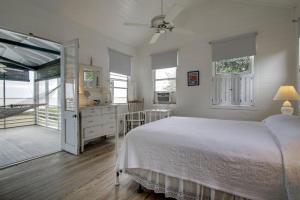 una camera da letto bianca con un letto e un bagno di 1111 Middle Street by AvantStay Charming Historic Cottage Featured in Dear John Movie Beach Access a Sullivan's Island