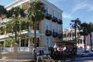 una carrozza trainata da cavalli di fronte a un edificio di 1111 Middle Street by AvantStay Charming Historic Cottage Featured in Dear John Movie Beach Access a Sullivan's Island