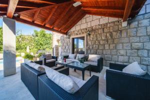 a patio with couches and a table on a stone wall at Villa Franica in Dubrovnik