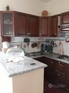 a kitchen with wooden cabinets and a counter top at Casa al lago in Lido Di Fondi
