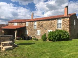 an old stone house with a grass yard at VUT Rural 2 in Arzúa