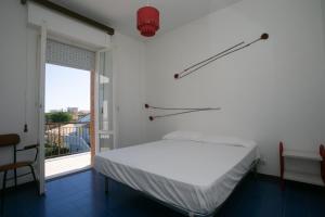 マルチェッリにあるMarcelli, trilocale con terrazzo a due passi dal mare - M046のベッドと窓のある白い部屋