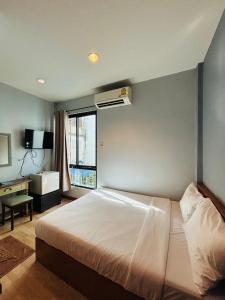 バンコクにあるThe LODGE BKK Hostelの白いベッドと窓のある寝室