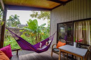a child laying in a hammock on a porch at Muri Lagoon Cottage in Rarotonga