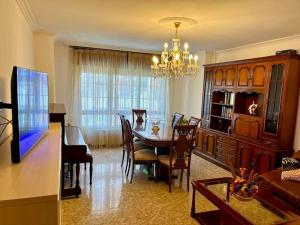 Una sala de estar con mesa de comedor y una sala de estar con lámpara de araña. en Adela, en Marín