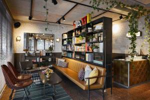 ein Restaurant mit einer Bank, einem Tisch und Stühlen in der Unterkunft The Saul in Tel Aviv