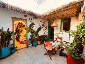 a patio with potted plants and a house at Art studio au bord de la mer in El Jadida