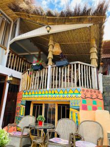 アル・ジャディーダにあるRiad art houseのバルコニーに椅子とテーブルが置かれたパティオ