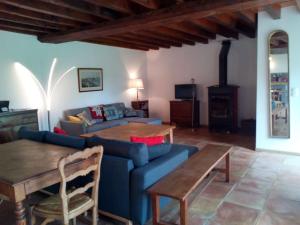 a living room with a blue couch and a table at Grande et belle maison ancienne restaurée in Écrainville
