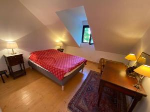 a bedroom with a bed and a table and two lamps at Grande et belle maison ancienne restaurée in Écrainville +8 photos