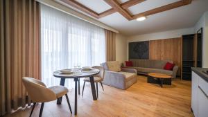 ein Wohnzimmer mit Tisch und Couch in der Unterkunft Resorts P Białka Tatrzańska z sauną, Sun & Snow in Białka Tatrzańska