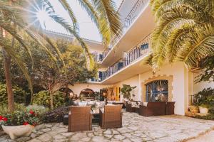 a restaurant with a table and chairs and palm trees at Hotel Bell Repos in Platja d'Aro
