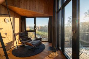a room with a chair and a large window at Treeangle - K1 Baumhaus in Odenthal